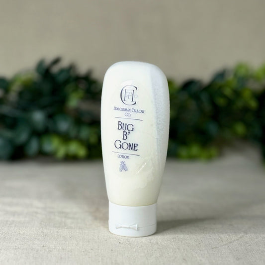 White bottle labeled 'Bug B Gone' on a textured surface with greenery in the background