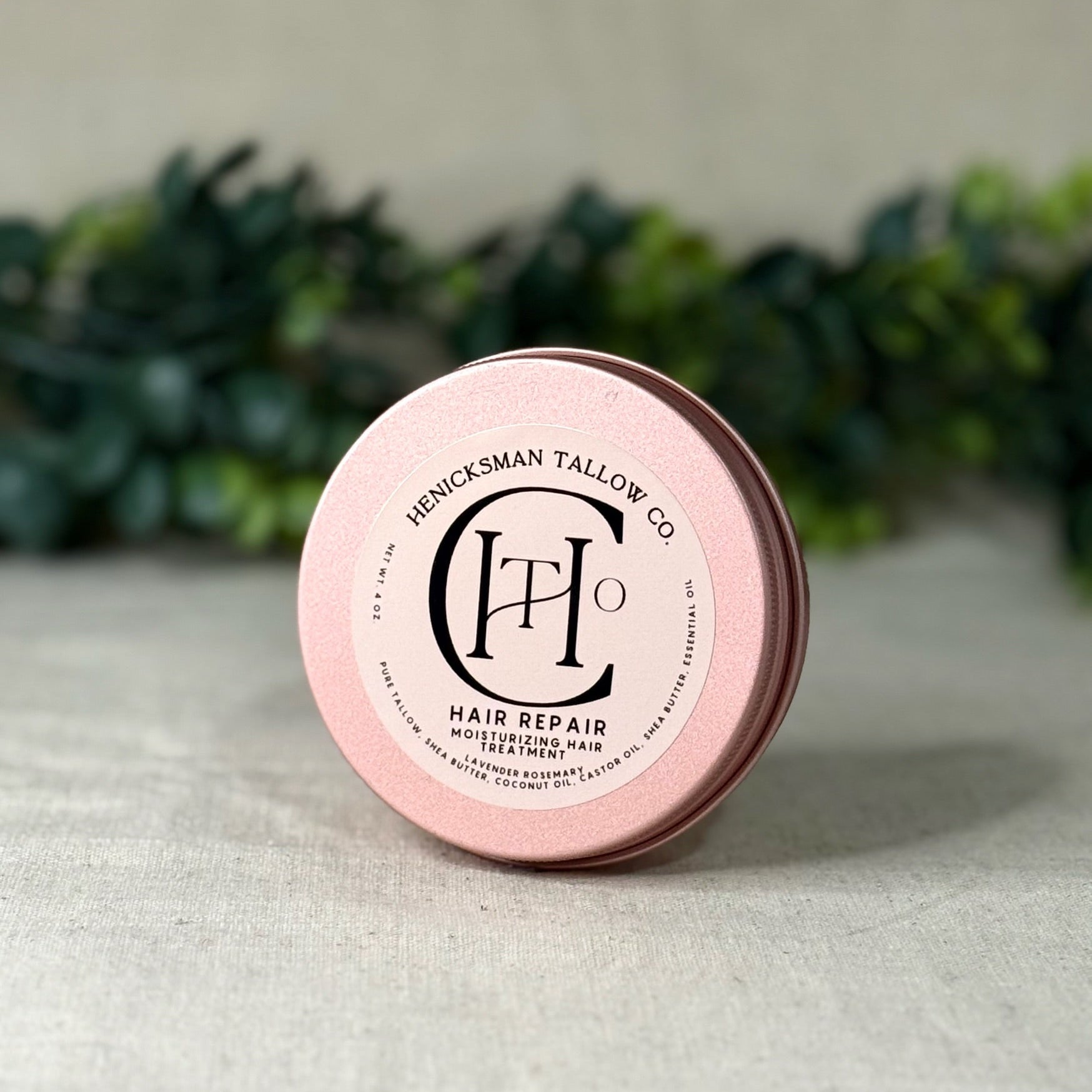 Pink hair repair product container with brand logo on a neutral background