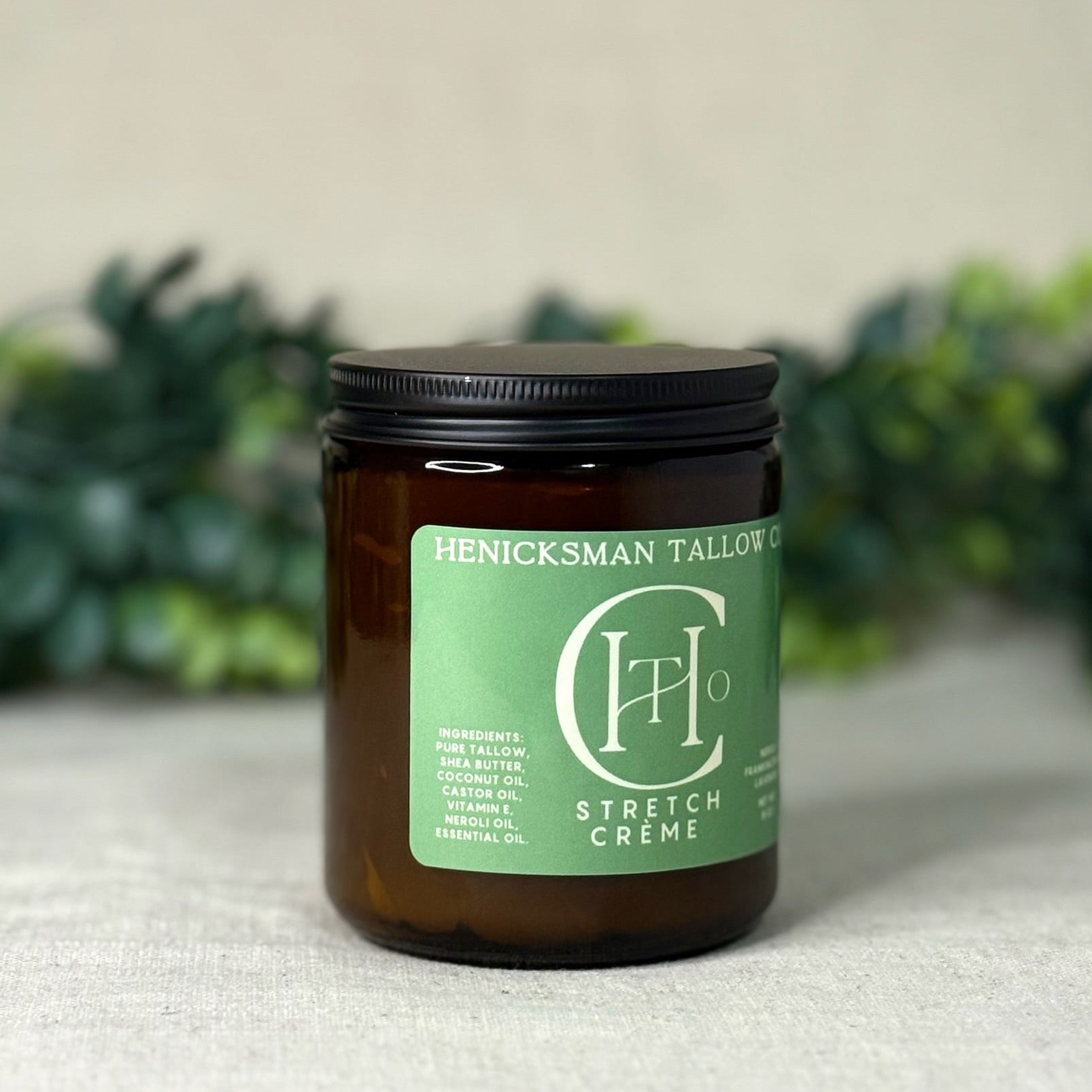 Jar of Henicksman Tallow Stretch Creme with green label on a neutral background