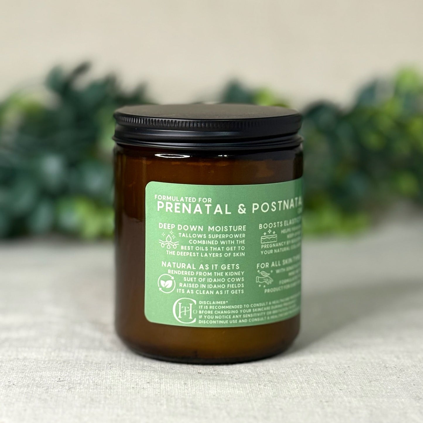 Jar of prenatal and postnatal product with green label on a textured surface with blurred greenery in the background