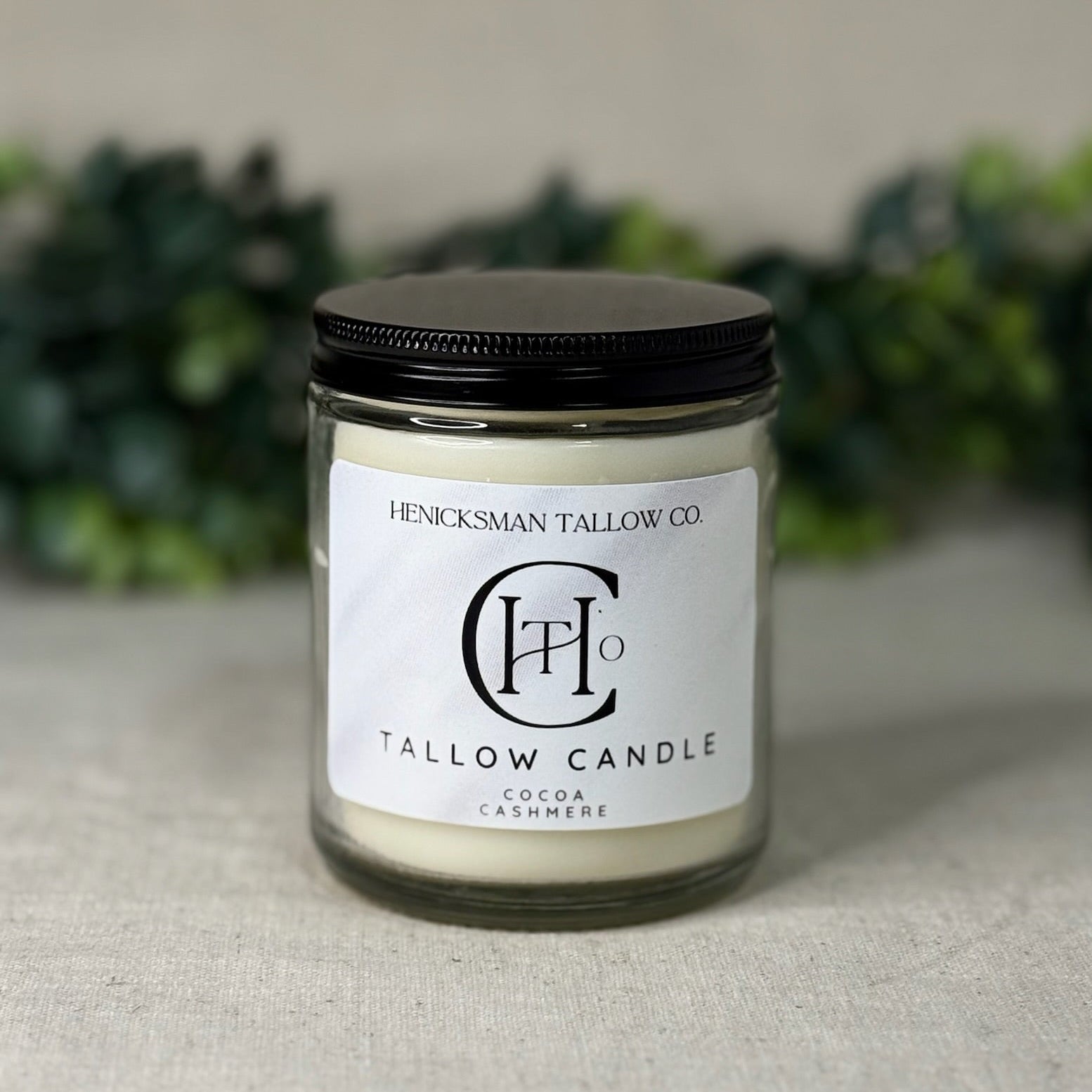 Tallow candle with a black lid on a neutral background
