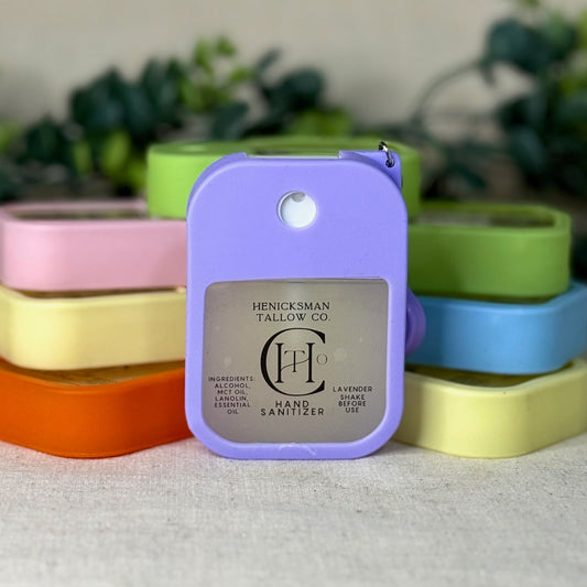 Purple hand sanitizer with brand logo on a white surface with colorful containers in the background.
